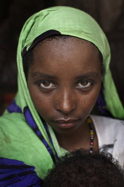 A portrait of 18 year old Suroro Mohamed Ali at the Dadaab refugee camp. She holds her nine month old child who was born when the drought in Somalia really started to affect people's lives in a critic...
