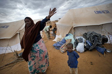 A woman and her child move to a tent at the IFO extension camp, a new part of the Dadaab refugee camp. Many of the recent arrivals at Dadaab are fleeing East Africa's worst drought for 60 years. The U...