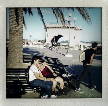 A young couple rest on a bench at Bastione San Remy in Cagliari, the capital of Sardinia.