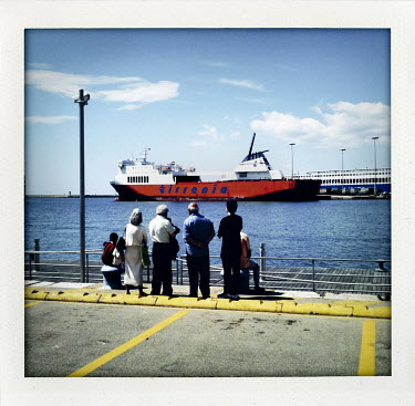 People watch boats at a harbour in Cagliari, capital of Sardinia.