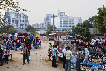 Wage labourers shop at a weekly market in Gurgaon. In the background is the American Express building and a few expensive residential buildings.