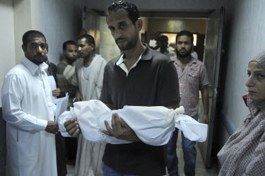 The uncle of a three month old girl shot dead by a sniper, presumed to be a Gaddafi loyalist, carries her shrouded body from a hospital. After a six month revolution, rebel forces finally managed to o...