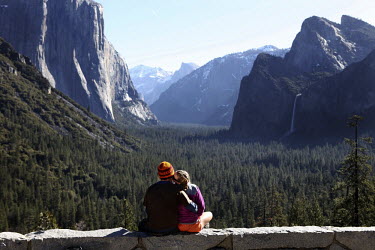 A couple admire the view at Yosemite, California, one of the most popular national parks with over 3 million yearly visitors. It is a World Heritage Site and recognised for its spectacular granite cli...