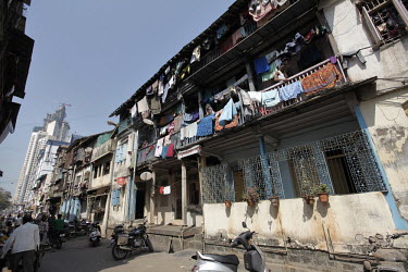 A modern high rise building contrasts the older buildings in the poor area of Bhuleshwar, central Mumbai.