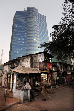 Shops and crumbling old buildings in front of a modern office building in the Arya Nagar area of Mumbai.