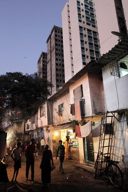 Shops and crumbling old slum buildings in front of a modern block of flats in the Arya Nagar area of Mumbai. As part of a development program the slum dwellers will eventually be offered housing in th...