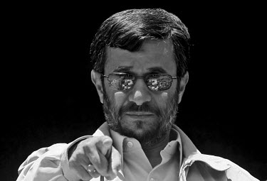 Iranian President Mahmoud Ahmadinejad points at one of his supporters in the crowd, seen partly reflected in his sunglasses, during a speech in the Iranian city of Shiraz.