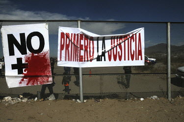 Slogans and banners on attached to the border fence. The slogan means 'No More Violence^.