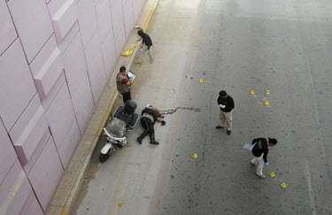 Police and forensic detectives at the sight of a killing, one of three that happened withint thirty minutes, two of which were traffic policemen.Ciudad Juarez, has been plagued by drug violence. With...