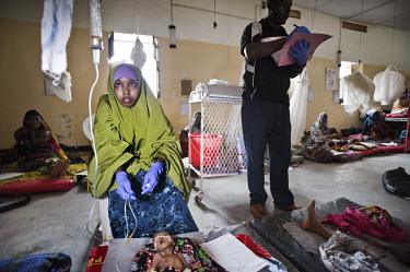 Nurses make their rounds in Galcayo hospital examining the intravenous fluids being given to a severely malnourished child. Galcayo is a town in the self-declared autonomous state of Puntland. The pop...