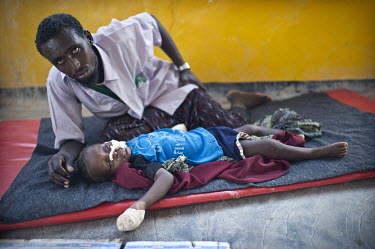 28 year old Abdirizak Hassan Guled with his two year old son Abdullah Abdirizak Hassan in the TFC (Therapeutic Feeding Centre) at Galcayo's hospital. The boy has pneumonia and malnutrition. Galcayo is...