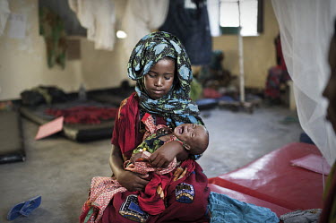 A young girl holds her baby sister in the TFC (Therapeutic Feeding Centre) ward at Galcayo's hospital. Galcayo is a town in the self-declared autonomous state of Puntland. The populace in the region s...