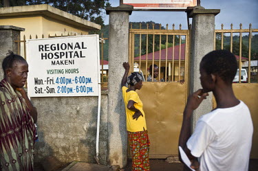 People wait in the early morning for the gates to the regional hospital in Makeni to be opened. A year ago Sierra Leone launched a free healthcare plan for pregnant women, breast-feeding mothers and c...