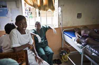 Nurses and widwives take a break during a shift as a pregnant woman lies on a bed at the regional hospital in Makeni. A year ago Sierra Leone launched a free healthcare plan for pregnant women, breast...