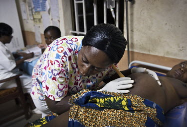 A nurse examines a pregnant woman at the regional hospital in Makeni. A year ago Sierra Leone launched a free healthcare plan for pregnant women, breast-feeding mothers and children under five years o...