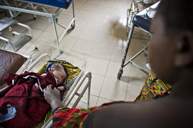 A mother comforts her newborn baby at the regional hospital in Makeni. A year ago Sierra Leone launched a free healthcare plan for pregnant women, breast-feeding mothers and children under five years...