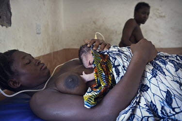 A mother holds her newborn baby in the maternity ward at the regional hospital in Makeni. A year ago Sierra Leone launched a free healthcare plan for pregnant women, breast-feeding mothers and childre...