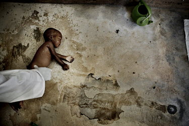 An eleven month old baby is prepared for burial in the Islamic manner where the body is washed and wrapped in a white cotton shroud. He died as a result of severe malnutrition.