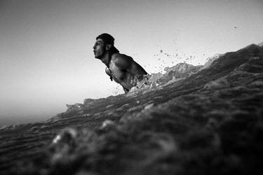 Ibrahim Alamassi, 22, breaks through the surf off Gaza City.