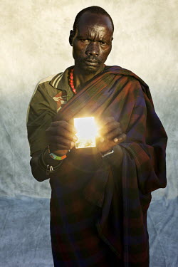 Lokoki Phillep reflects the sun's rays with a pocket mirror. He says he wishes for more rain for his crops