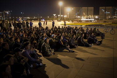 Migrant workers engaged in the construction industry in Ordos watch a revolutionary film projected in Linyinlu Square, Ordos. The Kangbashi District of Ordos, a district planned, five years ago, for 1...