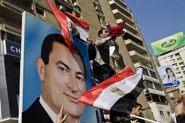 Pro-Mubarak elements wave Egyptian flags and hold up a huge picture of the president in a show of support during a rally in the district of Mohandeseen. 25 January 2011 saw the beginning of a nationwi...