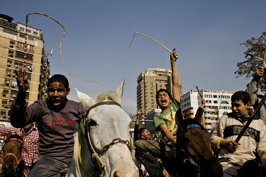 Young men, from the district of Giza, riding horses and brandishing whips arrive in the district of Mohandeseen to show their support for President Mubarak. 25 January 2011 saw the beginning of a nati...