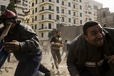 Anti-government protesters hurl rocks and stones at pro-Mubarak supporters just outside Tahrir Square. 25 January 2011 saw the beginning of a nationwide 18 day protest movement that eventually ended t...