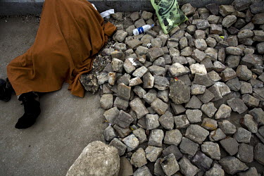 A man sleeps on the road next to a pile of rocks gathered to attack pro-Mubarak supporters during clashes in Tahrir Square. 25 January 2011 saw the beginning of a nationwide 18 day protest movement th...