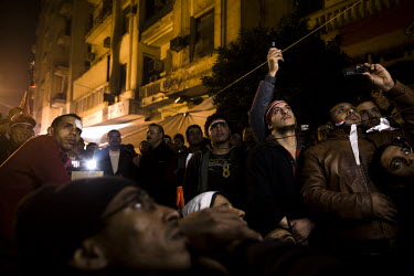 Anti-government protesters watch televised projections in Tahrir Square of a speech by President Hosni Mubarak. It is rumoured that the president is about to announce his resignation. 25 January 2011...