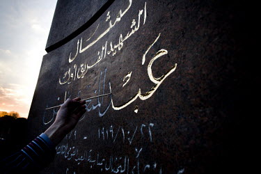 A young man re-paints the wording on a monument to the 1919 Egyptian revolution that is on the main roundabout into Tahrir Square. 25 January 2011 saw the beginning of a nationwide 18 day protest move...