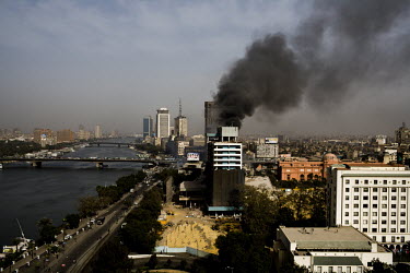 Smoke rises from the Interior Ministry building. To the right is the Egyptian Museum of Antiquities in Tahrir Square and the Nile River is on the left. The Interior Ministry building was destroyed dur...