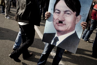 President Hosni Murbarak caricatured as Adolf Hitler on a placard carried by an anti-government protester during a demonstration in Tahrir Square. 25 January 2011 saw the beginning of a nationwide 18...