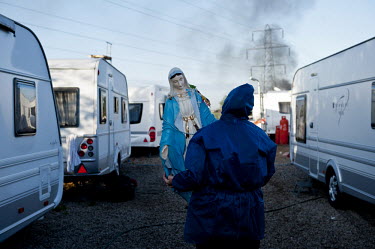 A resident of Dale Farm carries a statue of the Virgin Mary to safety during the eviction of the traveller site in Essex.