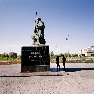 A couple meet in the shadow of a monument to a famous Karakalpak in central Nukus.
