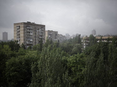 A view of high rise housing blocks and trees growing between them.