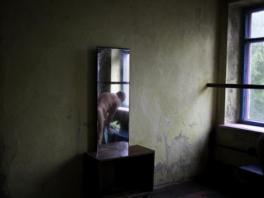 A miner, reflected in a mirror, dries himself following a shower in the Navagrodovskaya coal mine, West Donetsk.