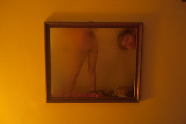 A couple reflected in a mirror in a hotel room.