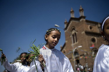 Children in white robes walk in a procession in front of St Joseph's Catholic Cathedral .