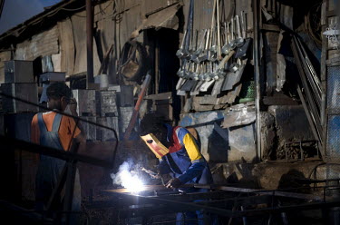 A welder with a home made protective mask works on scrap metal at the Medeber scrap metal market. The huge Medeber market is the centre of Asmara's recycling industry where thousands of household and...