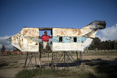 A boy plays on an aeroplane shaped playground structure at Asmara's expo area. The plane is a relic from Eritrea's liberation struggle for independence from Ethiopia. ERI, Eritrea, Asmara, 15.10.2011B...