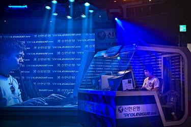 Players inside a game station compete against their opponent during a live StarCraft ProLeague online gaming tournament while their teammates watch their moves on computer screens.