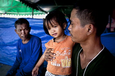 A man and his daughter at an evacuation centre on the outskirts of Bangkok. Large parts of central and northeastern Thailand have been severely affected by the worst flooding for seventy years. More t...