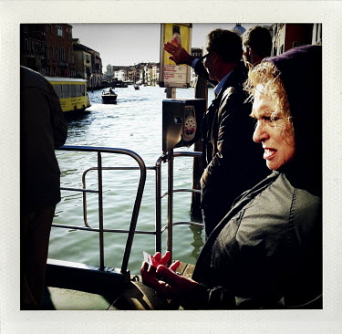 An elderly women waits for a public bus-boat by the Grand Canal.