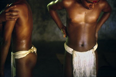 Boys oil themselves before a massage by a teacher. Massage is seen as an essential part of Kathakali training, a stylised dance drama of Kerala, making the boy's bodies supple and strong.
