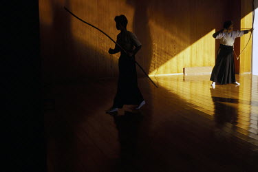 Two female Kyodo practitioners at the dojo (practice hall) in Kyoto. Kyudo is a modern Japanese martial art derived from ancient Samurai archery, heavily influenced by Zen Buddhist philosophy.