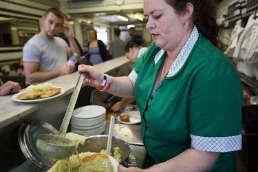 Kelly serves customers eels, pie and mash in Manze's Eel, Pie and Mash shop on Tower Bridge Road in London. This pie shop was opened in 1897 and is the oldest pie and eel shop in the country.