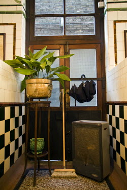 An antique flower pot stand, a broom and an umbrella in Manze's Eel, Pie and Mash shop in Walthamstow, East London. Although the shop still trades under the original Manze name, it is now independentl...