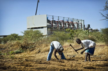 Two men clearing land in front of the Chinese owned New Sukala sugarcane factory between Markala and Niono. The Chinese are irrigating thousands of hectares to grow sugarcane, a crop that requires a l...