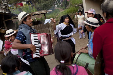 People, dressed up and playing musically instruments  dance house to house, sharing food with their neighbours during Carnival.